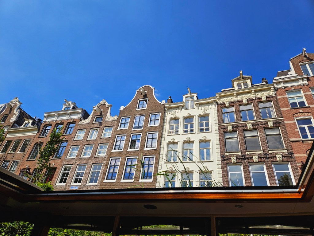 Tall, narrow Dutch houses overlooking a canal in Amsterdam