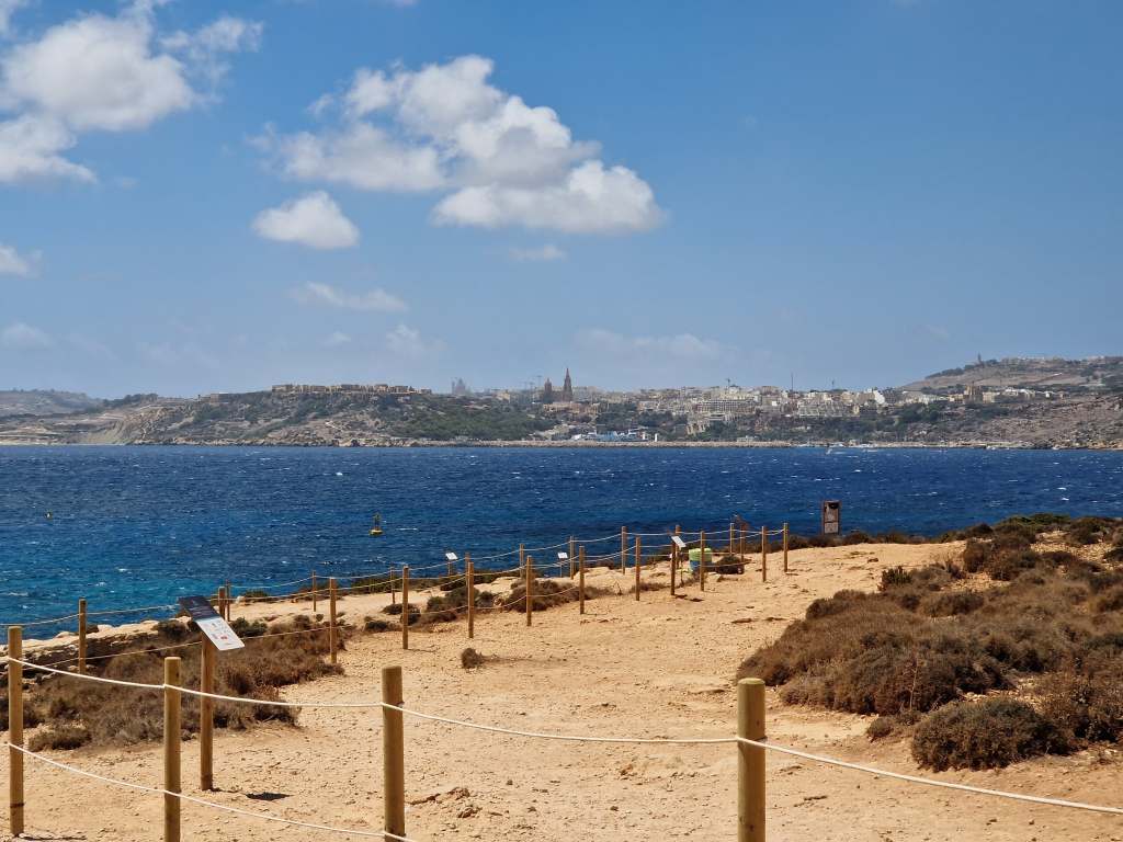Gozo across the sea, as seen from the island trail in Comino.