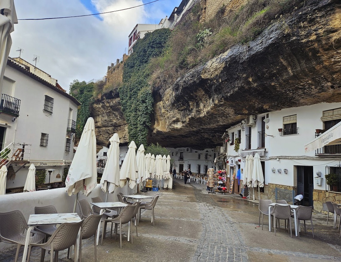 Restaurants and houses beneath the enormous overhanging cliff of Calle Cuevas del Sol, one of the most recognised and postcard perfect streets in Setenil de la bodegas.